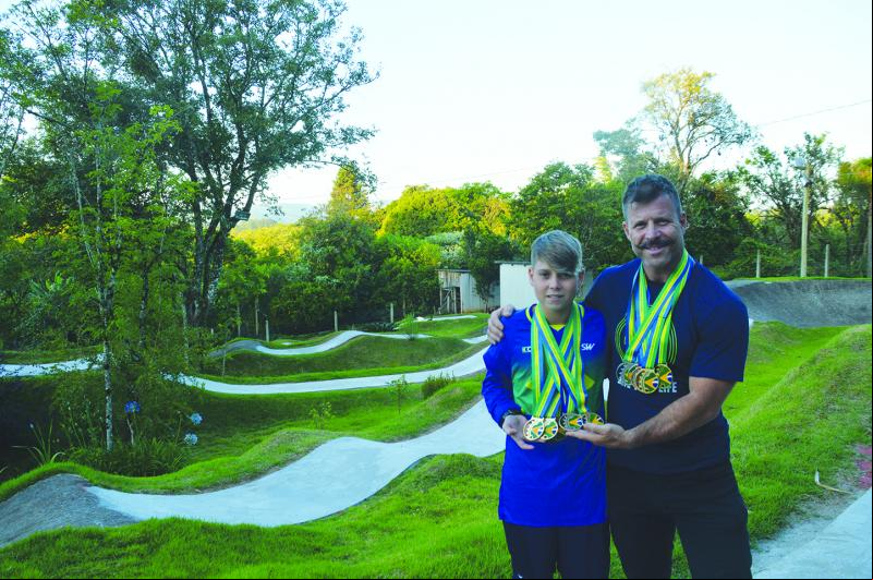Pietro e Edson mostram orgulhosos as medalhadas conquistadas nos últimos anos. Ao fundo, a pista exclusiva, no pátio de casa